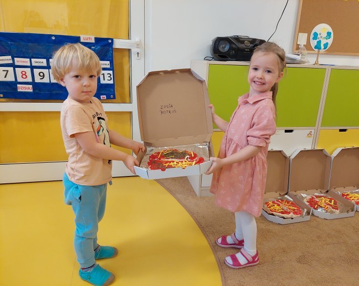 dzieci trzymają pizzę